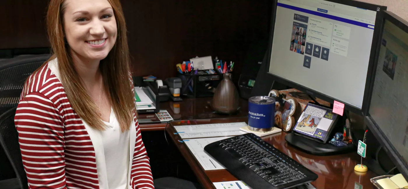 Student intern smiling while working on computer